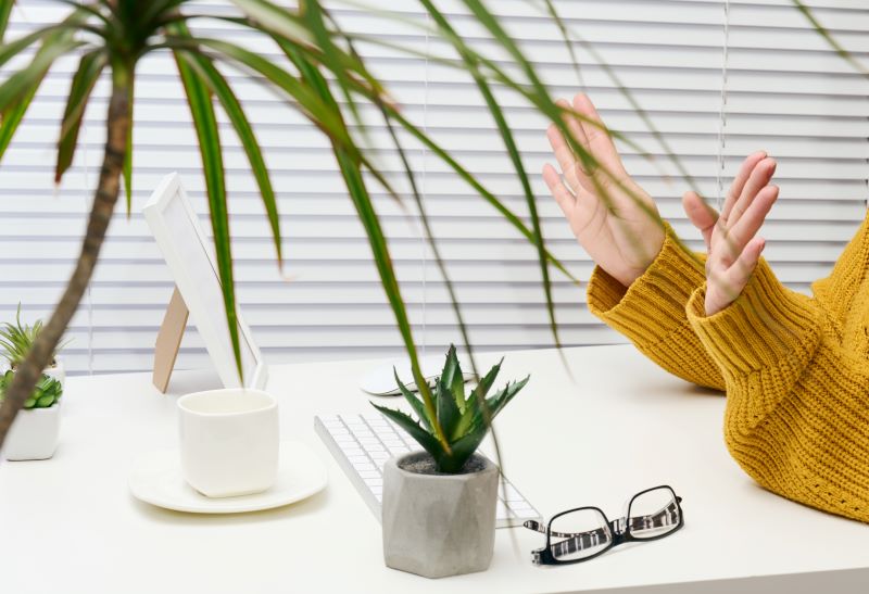 woman sits at a white desk and gestures with her hands